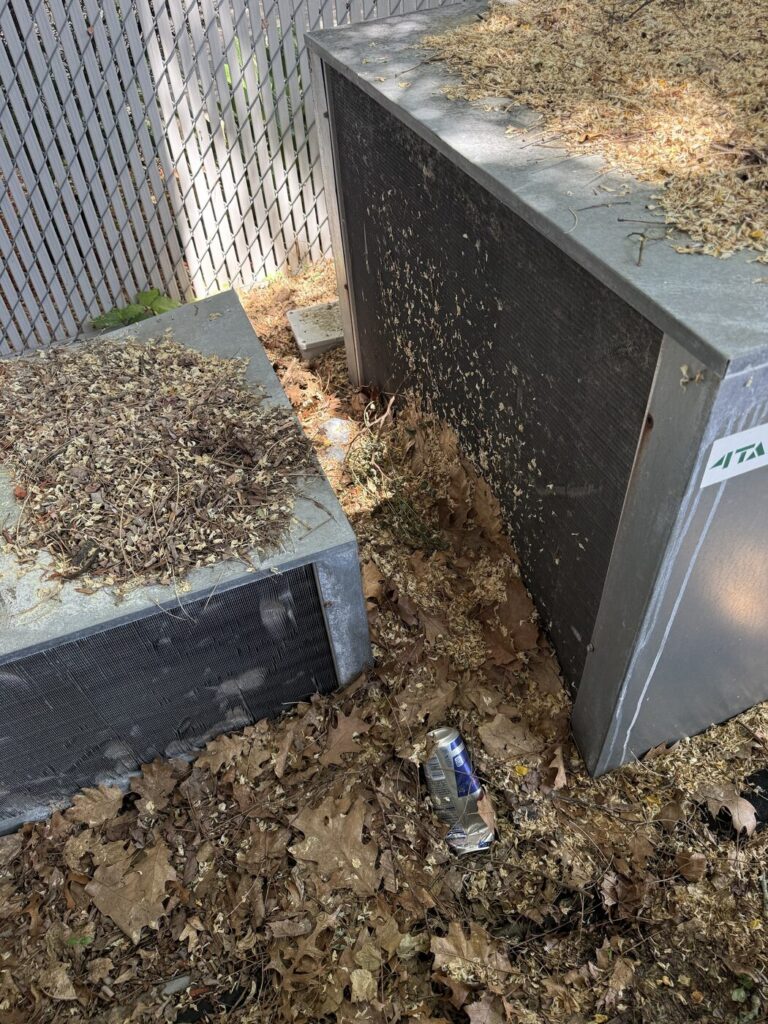 Dirty outdoor condenser coils clogged with leaves and yard debris