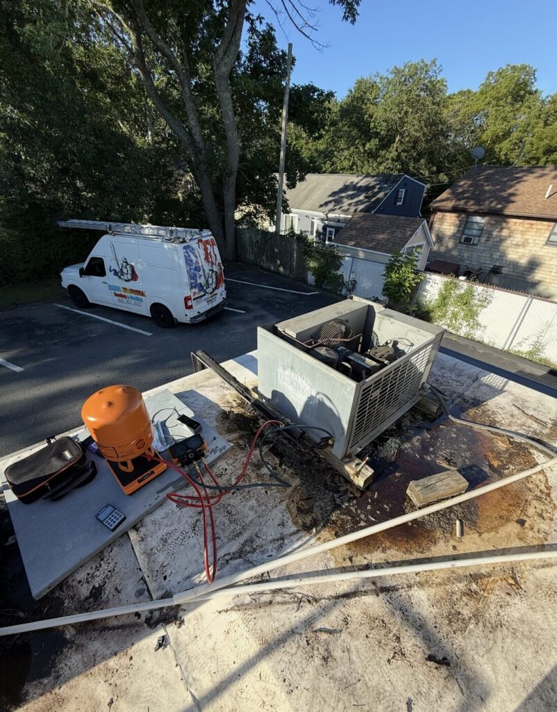 Armus Refrigeration technician servicing a commercial condensing unit with manifold gauges in New Bedford MA