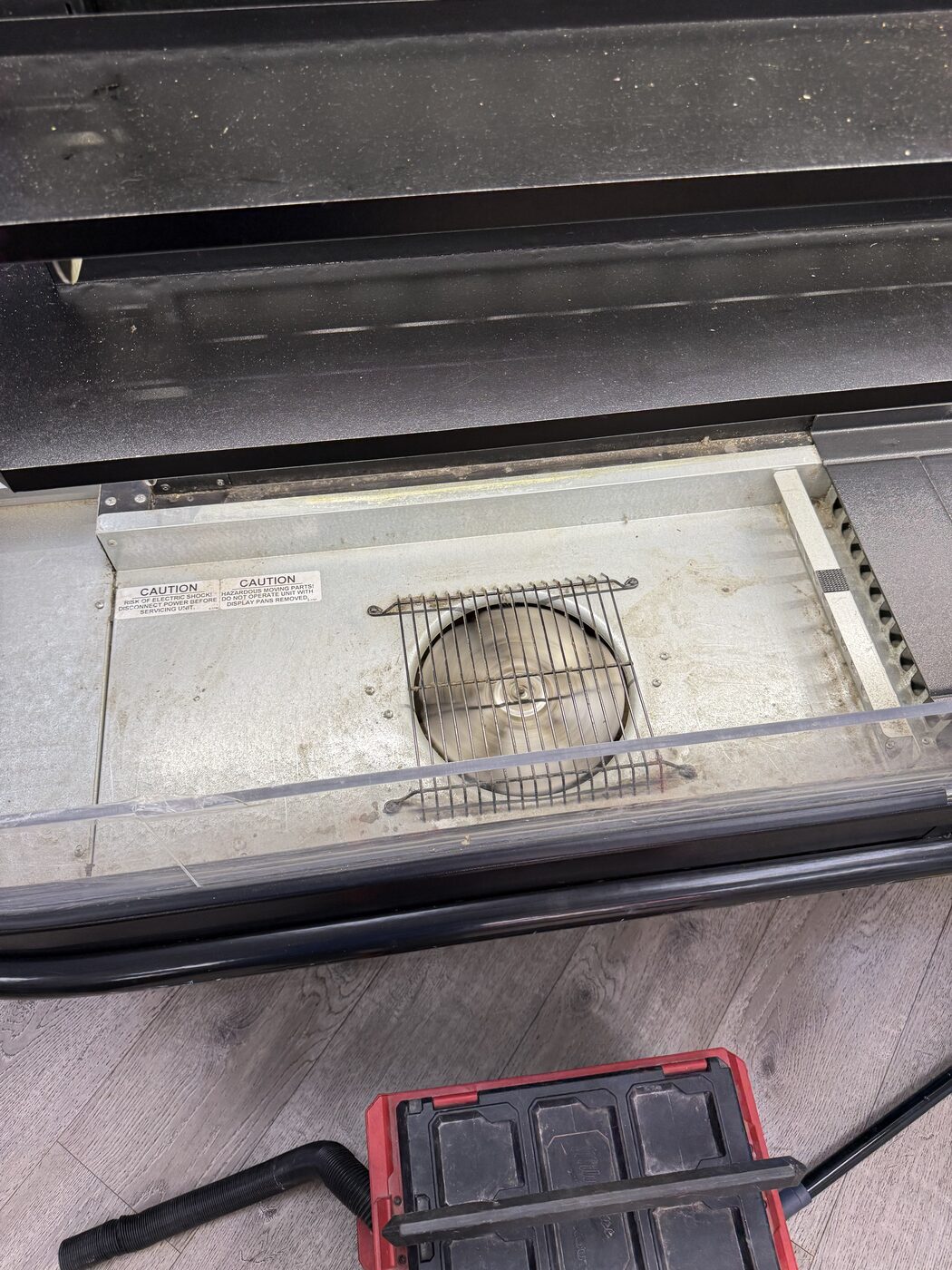 Cleaned evaporator fan and base deck inside a commercial display case after service