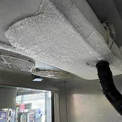 Heavy frost and ice buildup on a walk-in unit ceiling evaporator coil