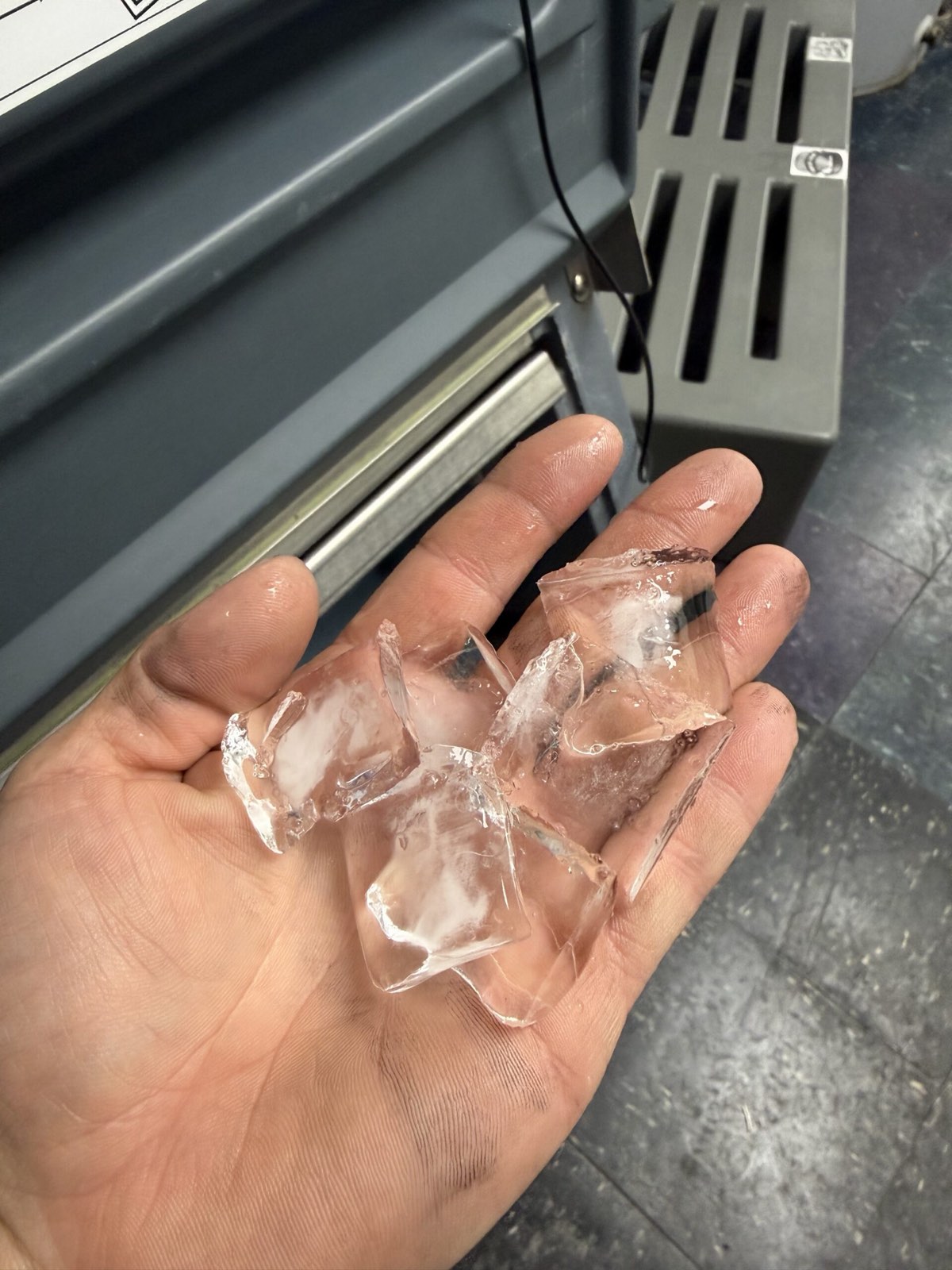 Hand holding clear ice cubes from machine — commercial ice machine repair, Armus Refrigeration (MA & RI)