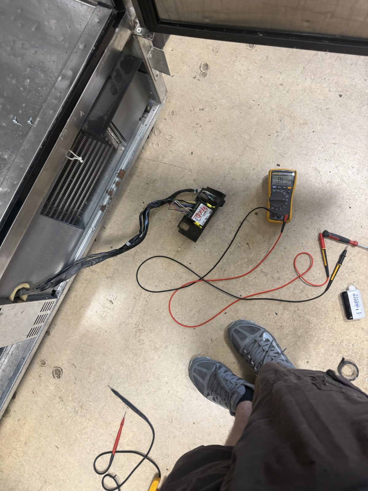 technician testing reach-in cooler wiring with multimeter — reach-in cooler repair, armus refrigeration (ma & ri)