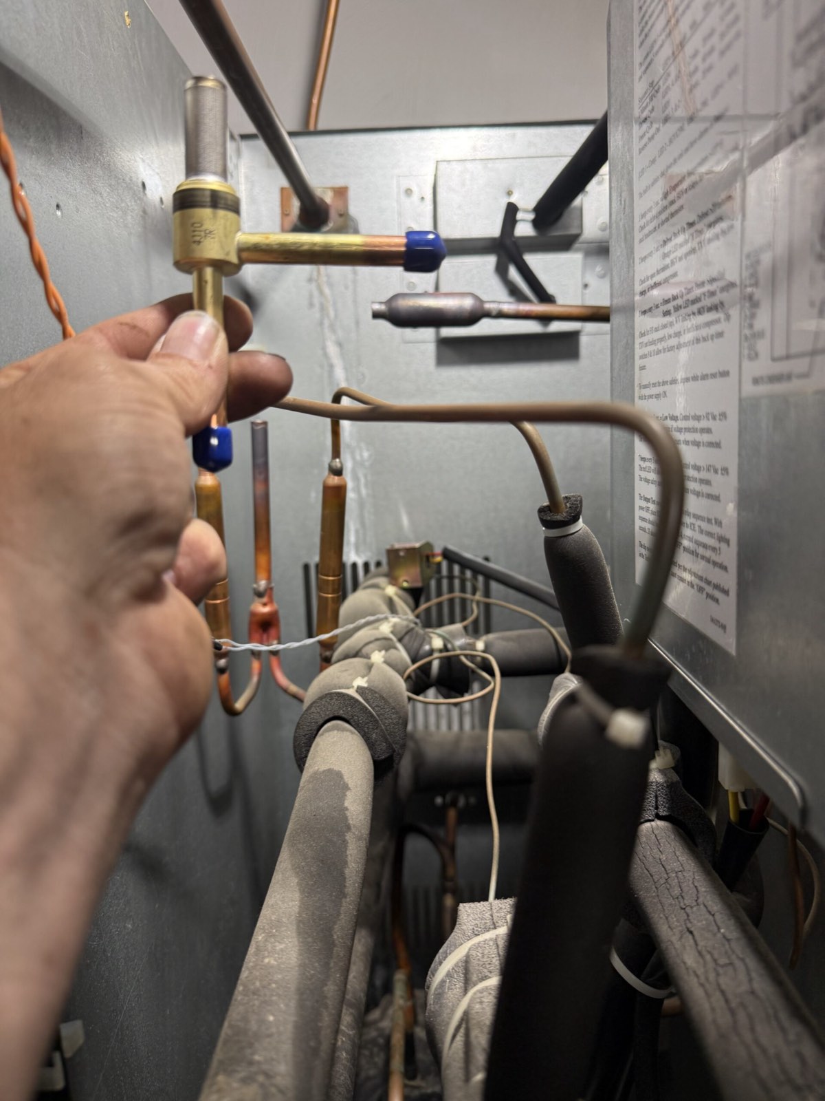 Hand holding refrigeration filter drier component — commercial refrigeration service, Armus Refrigeration (MA & RI)